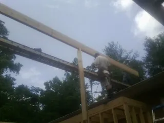 Carpenter setting a ridge beam over a new addition frame — Ice Dam Removal by Roofing Brothers in Eastford