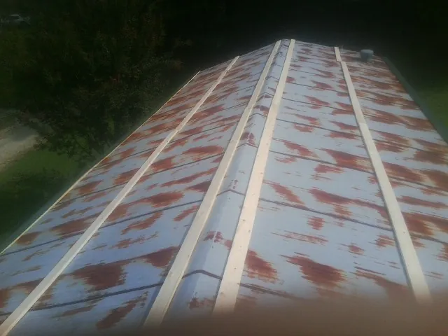 Rusted metal roof panels with new wood purlins before replacement — Storm Damage Roof Repair in Eastford by Roofing Brothers