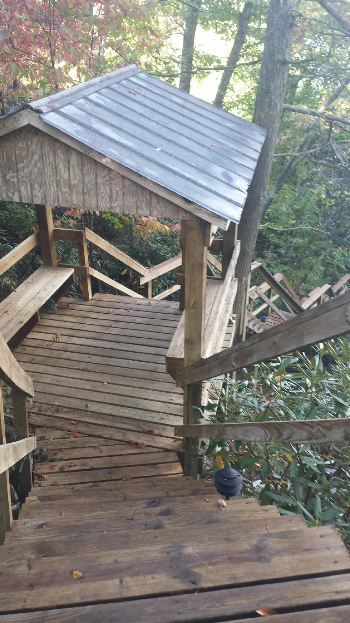 Metal roofed shelter over wooden steps on a wooded walkway — Skylight Repair & Installation work by our crew in Eastford