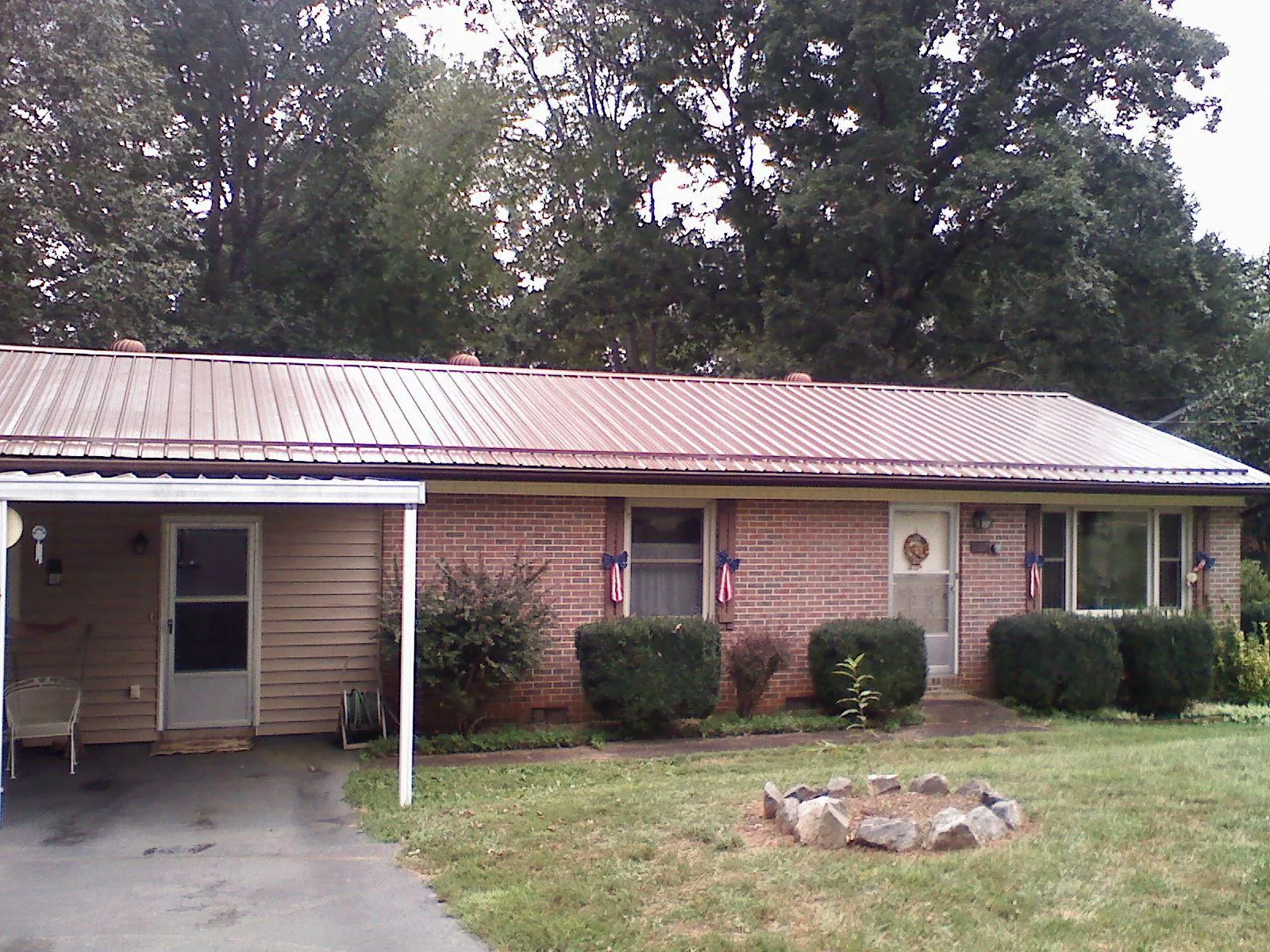 Bronze metal roof and carport on a brick ranch home — Roof Repair work by our crew in Eastford